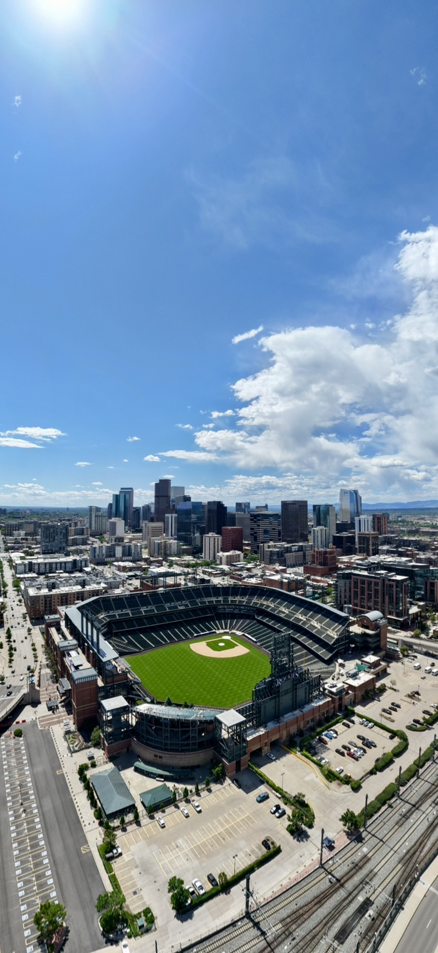 Aerial drone photograph of a downtown skyline with a baseball ballpark in the foreground on a clear day